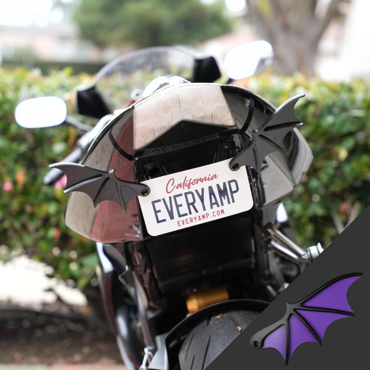 The rear view of a black motorcycle features License Plate Bat Wings decorated from recycled PETG, branded EveryAmp. The plate reads California EVERYAMP, with an inset showing the purple and black bat-wing detail.