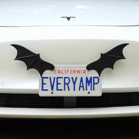 A white Tesla with California plates reading EVERYAMP displays black License Plate Bat Wings by EveryAmp, mounted on a SnapPlate made from recycled PETG plastic.