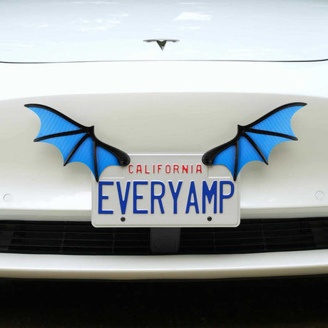 A white car with a California plate EVERYAMP and SnapPlates is uniquely adorned with EveryAmp’s blue License Plate Bat Wings, adding a quirky flair.