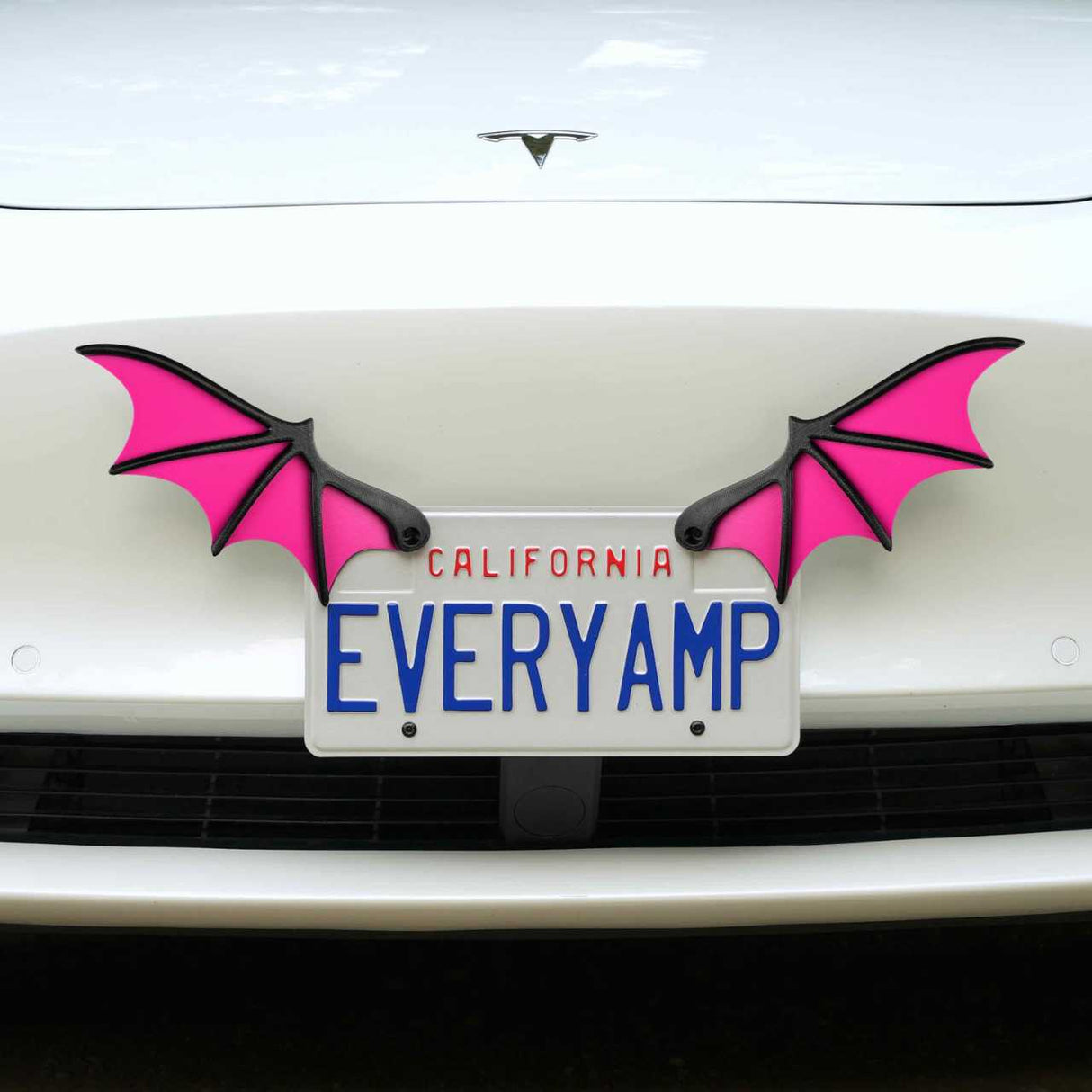 A white car with a California license plate EVERYAMP is adorned with EveryAmps magenta License Plate Bat Wings. This unique setup includes SnapPlates made from recycled PETG plastic for a stylish and sustainable display.