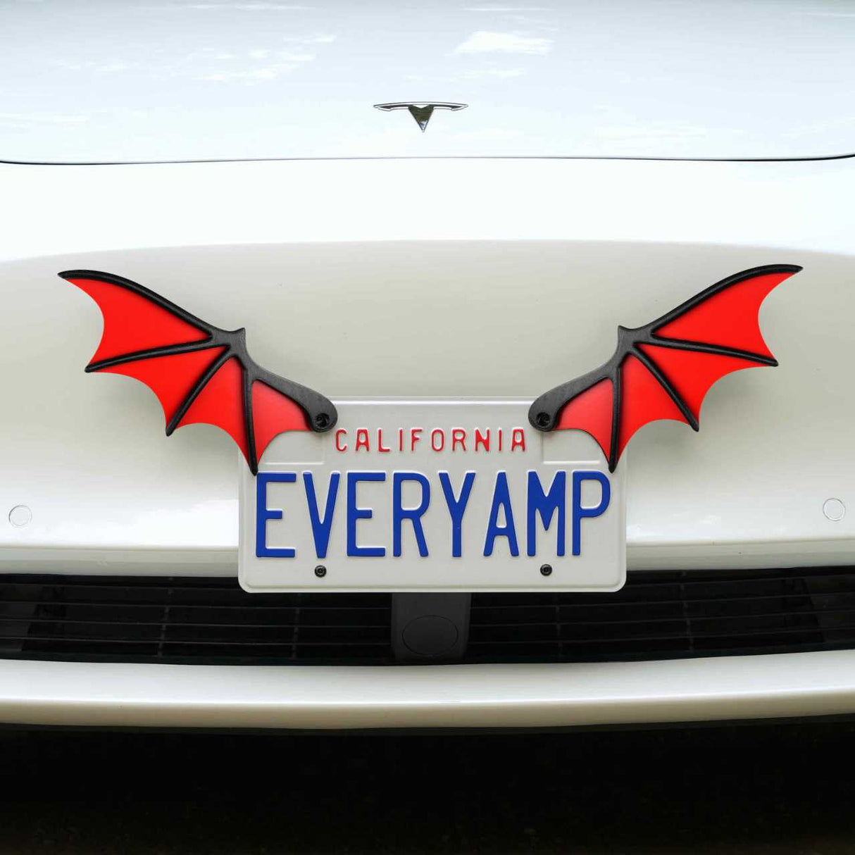A car sporting a California plate EVERYAMP displays two red License Plate Bat Wings from EveryAmp. These wings enhance its SnapPlates feature, made from recycled PETG plastic, adding an eco-friendly flair to its design.