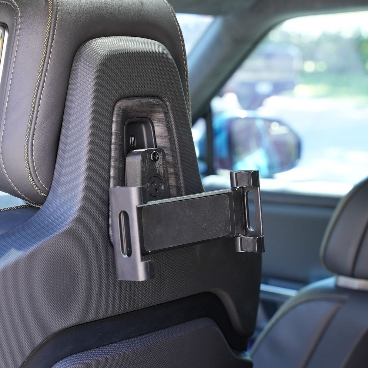 The EveryAmp Back Seat Tablet/Phone Mount Anchor for Rivian R1T and R1S attaches to the car seat headrest, providing an ideal, secure position for passengers in the back seat to use their devices.