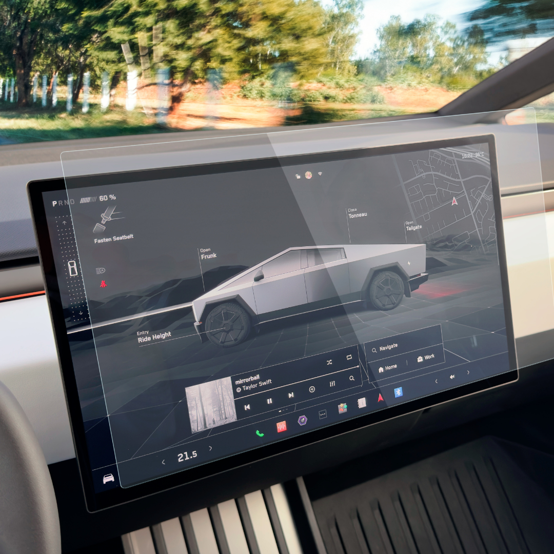 Inside the car, the digital dashboard displays a 3D futuristic truck model, navigation map, and media controls. Protected by Abstract Oceans Ultra-Premium Tempered Glass (9H) Screen Protector for Cybertruck, clarity is maintained while greenery peeks through the windows.