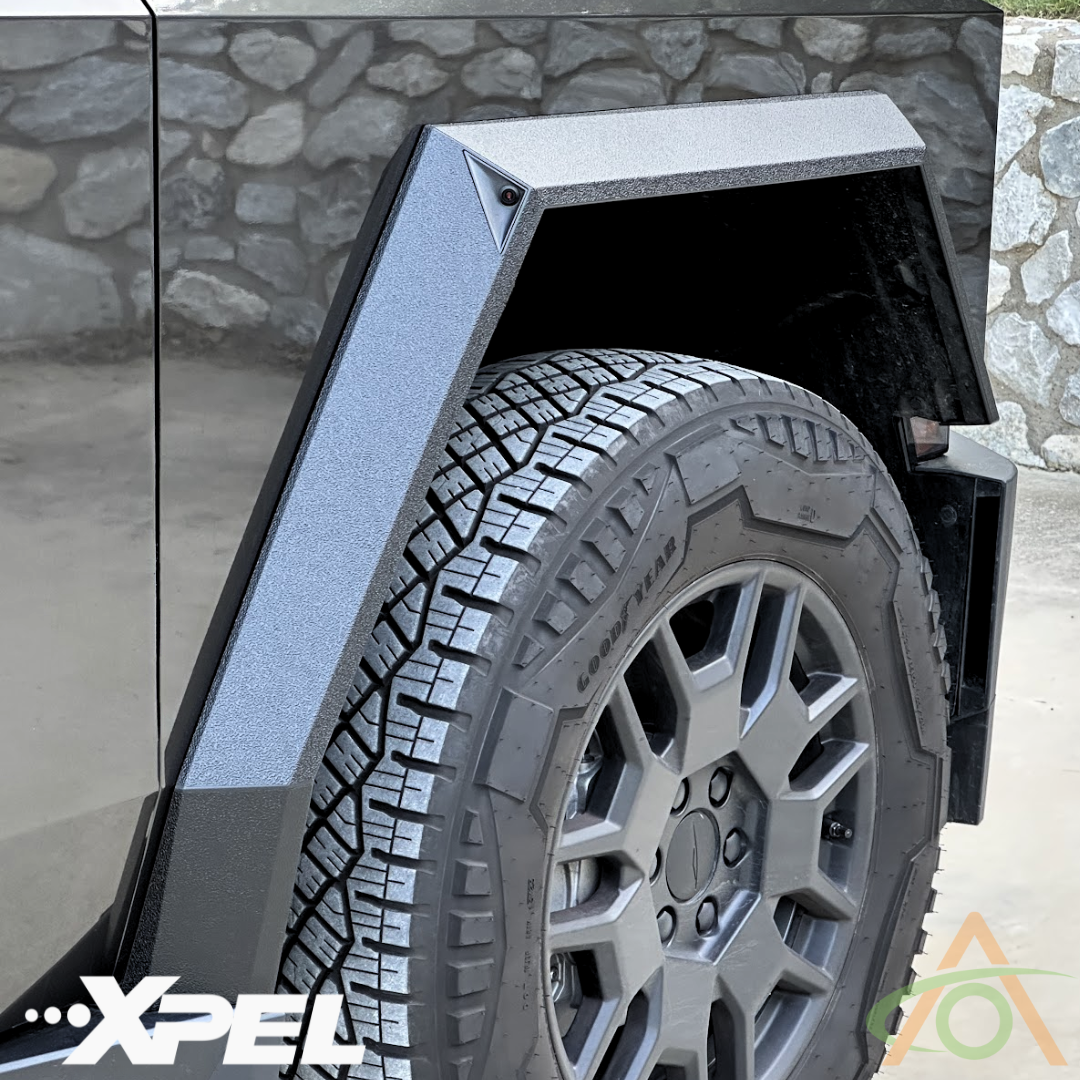 Close-up of a vehicles textured fender featuring Ultra-Tough Xpel Armor Fender Flares by Abstract Ocean for Cybertruck and a durable all-terrain tire. Branding logos are visible in the bottom corners.