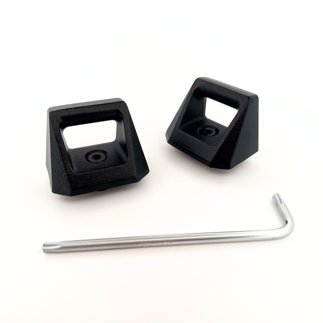 The Cybertruck L-Track Accessories from Abstract Ocean, featuring two black plastic brackets with rectangular openings and a silver hex key, are ideal for your vault setup on a white background.