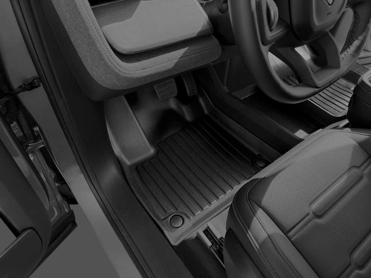 Black, custom-fitted LinerX Floor Mats for Rivian R2 (2027) installed in the driver’s side footwell of a vehicle.