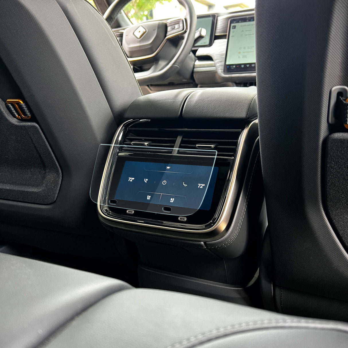 Car interior featuring a digital control panel with an Abstract Ocean Ultra-Premium Tempered Glass (9H) Screen Protector for rear-seat climate and audio settings, conveniently located between the front seats of the Rivian R1T/R1S.