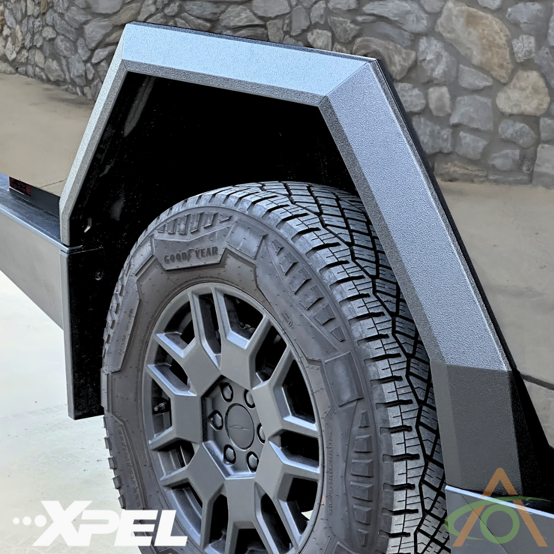 Close-up of a Cybertruck wheel with Abstract Oceans Ultra-Tough Xpel Armor Fender Flares, featuring a textured finish. The logo XPEL is visible on the bottom left, showcasing advanced protection and durability.