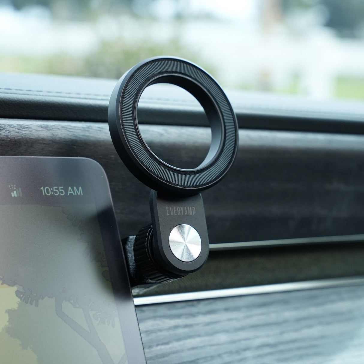 Close-up of an EveryAmp Phone Mount Dash Anchor for Rivian R1T and R1S, featuring a sleek MagSafe charger with a circular design and metallic center. A digital display beside it shows the time as 10:55 AM.