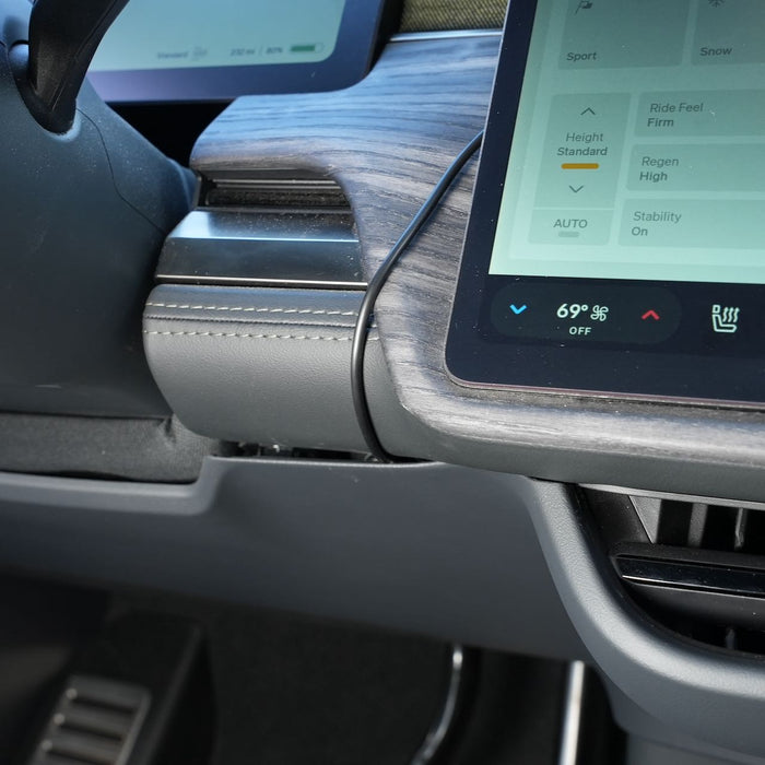 Car dashboard close-up showing a touchscreen with climate control settings, wood trim, and visible USB cable. Temperature is set to 69°F.