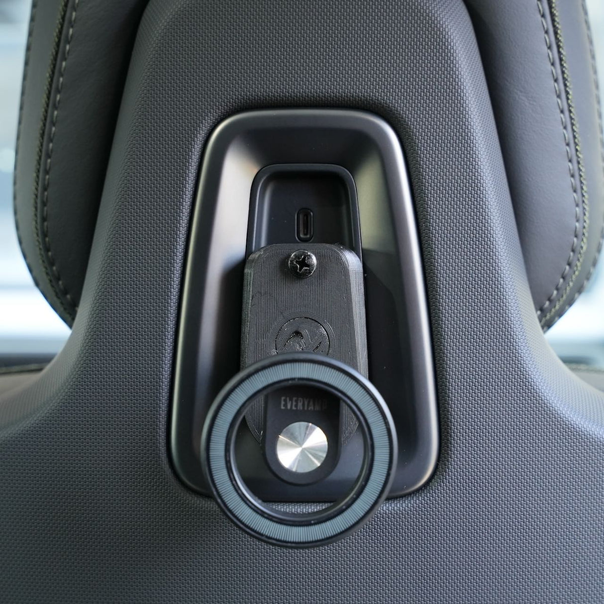 Close-up of a car seat headrest with EveryAmps Back Seat Tablet/Phone Mount Anchor, a perfect accessory for mounting devices in your Rivian R1T or R1S.