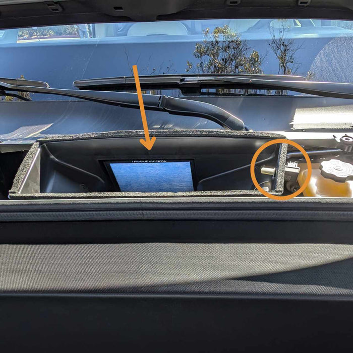 Dashboard with a rectangular screen embedded, highlighted by an arrow. A circular element, circled in orange, is visible near the wiper blades.