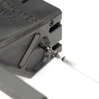 Close-up of a 3D-printed component with a metal rod inserted into a threaded hole, secured by a screw. The object is black with engraved text on its surface.
