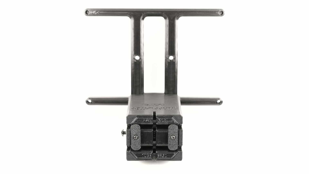 Close-up of a black mechanical component featuring a distinct I-shaped frame and a protruding part with a grid-like structure, set against a plain white background.