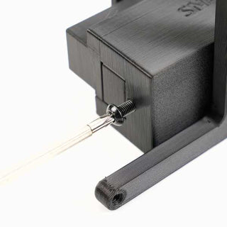 Close-up of a black 3D-printed bracket securing a slender rod or antenna with a screw threaded through the bracket.