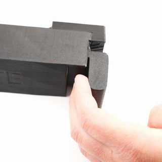 A 3D-printed black plastic mechanism with a sliding part is being operated by a hand on a white background.