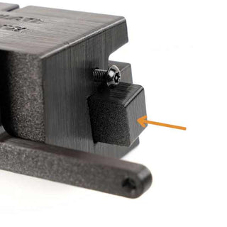 Close-up of a black, 3D-printed object with a triangular component attached by a small screw. An orange arrow points to the triangular section.