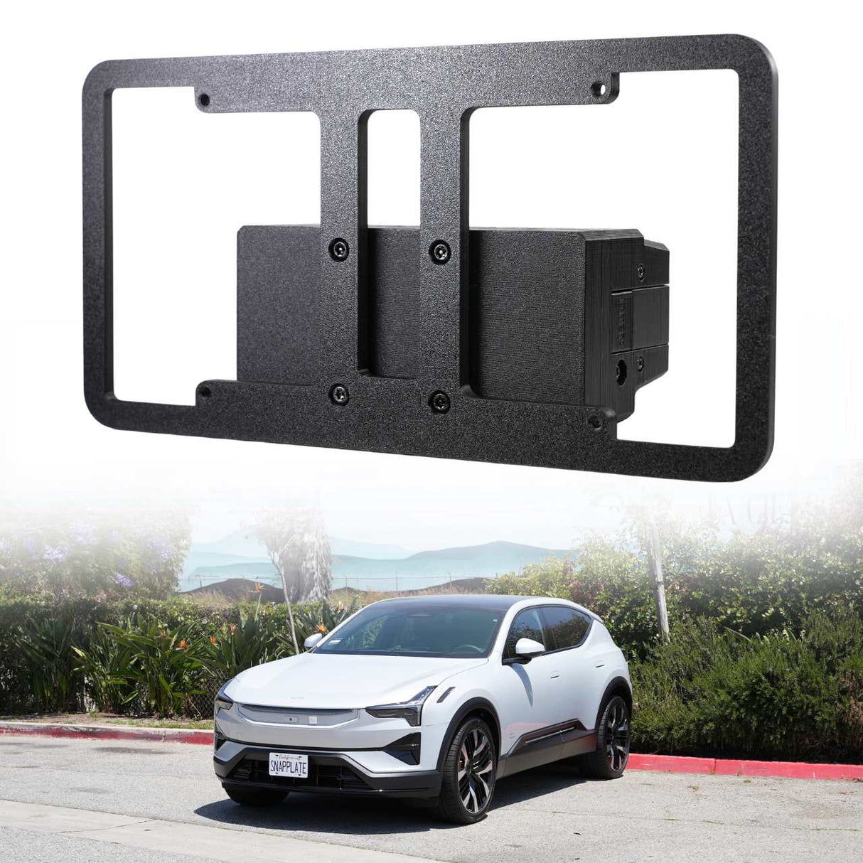 The EveryAmp Polestar 3 Front License Plate Holder, No Drill, SnapPlate in black recycled PETG is shown above a white Polestar 3 electric SUV parked on the street with greenery in the background.