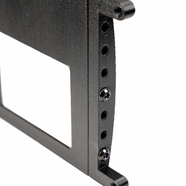Close-up of a black metal bracket with a series of holes and three visible screws.