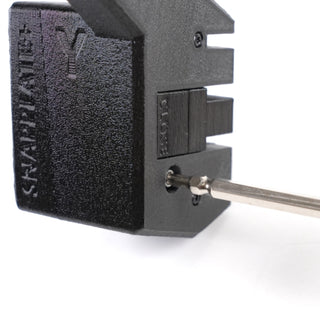 A screwdriver tightening a screw on a black 3D-printed Snapplate device.