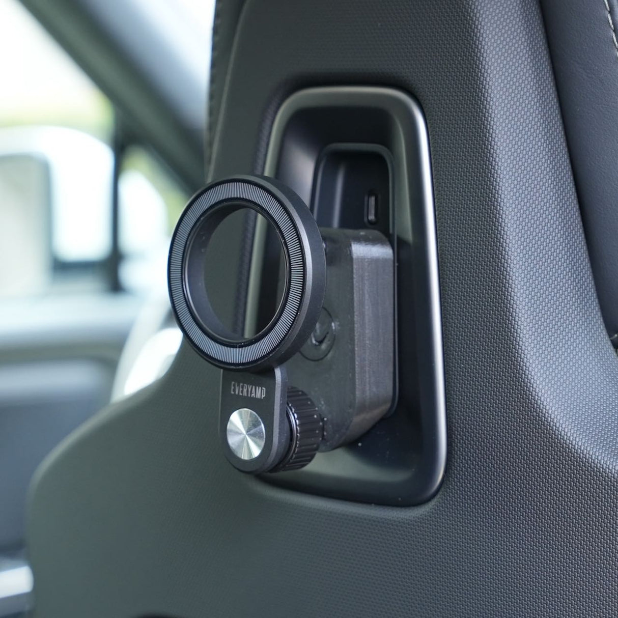 A close-up of the EveryAmp Back Seat Tablet/Phone Mount Anchor for Rivian R1T and R1S, attached to the car seat headrest with a 3D-printed ball mount and EveryAmp branding—perfect for your Rivian accessory needs.