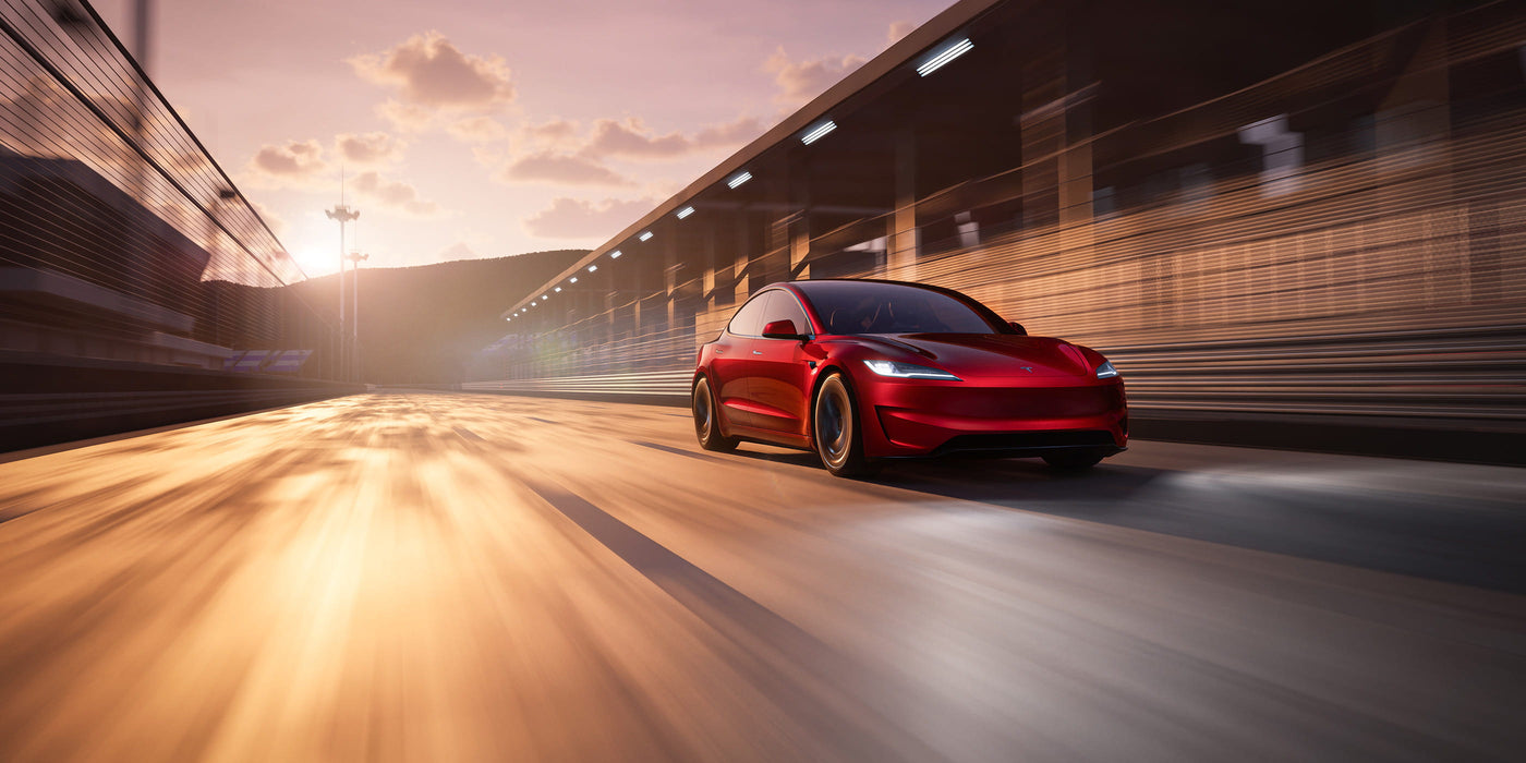 A red car drives swiftly on a road with motion blur, under a pinkish sky at sunset or sunrise.