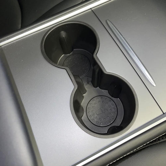 Car interior with two cup holders in a central console, featuring a modern design with a sleek finish.