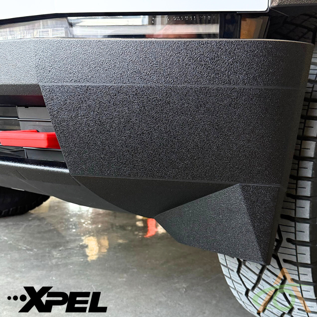 Close-up view of a Cybertrucks textured corner bumper and tire, highlighting the Ultra-Tough Xpel Armor Front Bumper Protection by Abstract Ocean. The XPEL logo appears prominently in the bottom left corner.