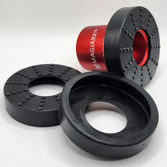 Three Magjaxx brand black and red mechanical components, each with central circular holes and detailed surface textures, positioned on a white surface.