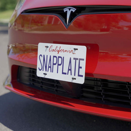 Red Tesla car with a California SNAPPLATE license plate attached to the front bumper.