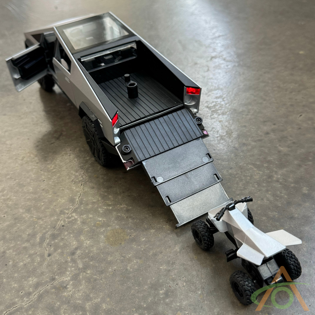 The 1:24 Scale Cybertruck + Cyberquad Diecast by Abstract Ocean showcases a futuristic design, with the tailgate forming a ramp to a toy ATV resembling the Cyberquad. The models side door is open while it sits on a smooth, gray surface.