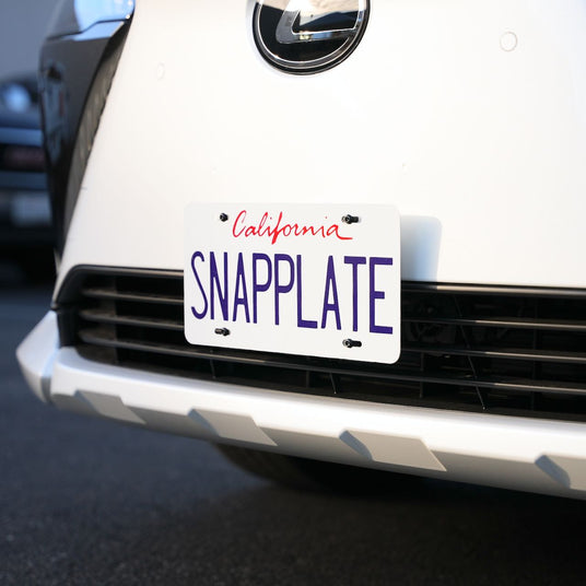 Close-up of a cars front bumper displaying a license plate with the word SNAPPLATE in bold letters and California in small red letters above.