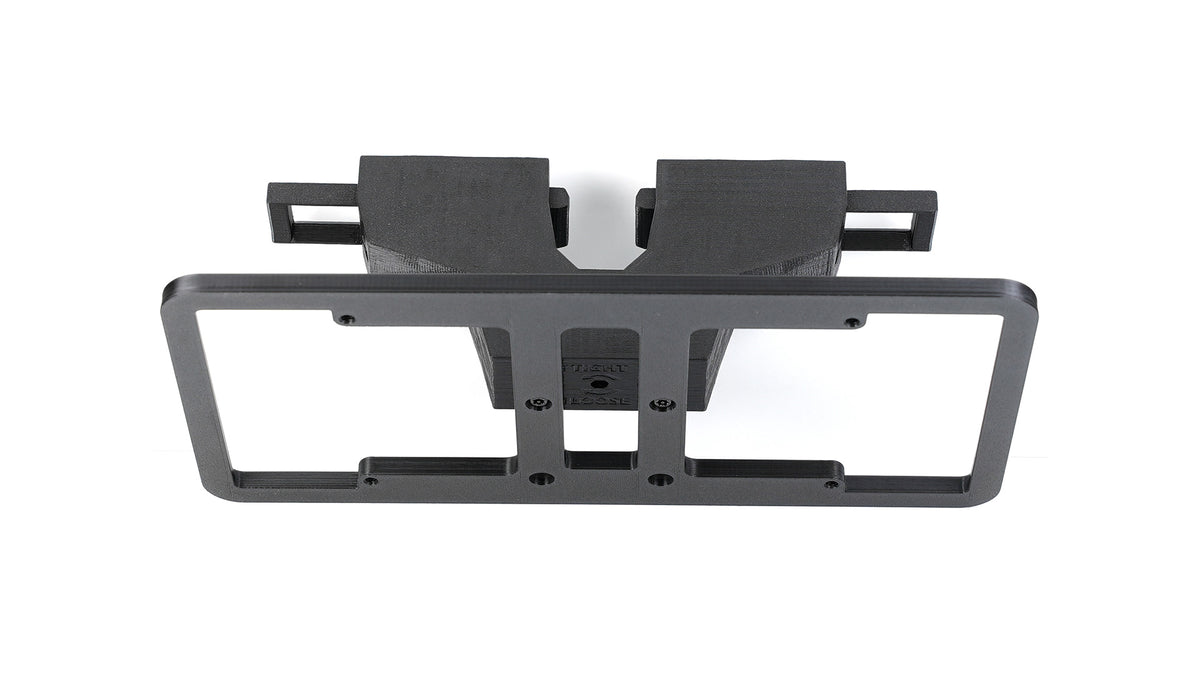 Black plastic mounting bracket with two rectangular slots and a rectangular frame on top, viewed against a white background.