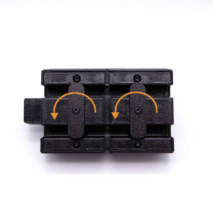 A black mechanical component with two rotating levers, marked by orange arrows, on a white background.