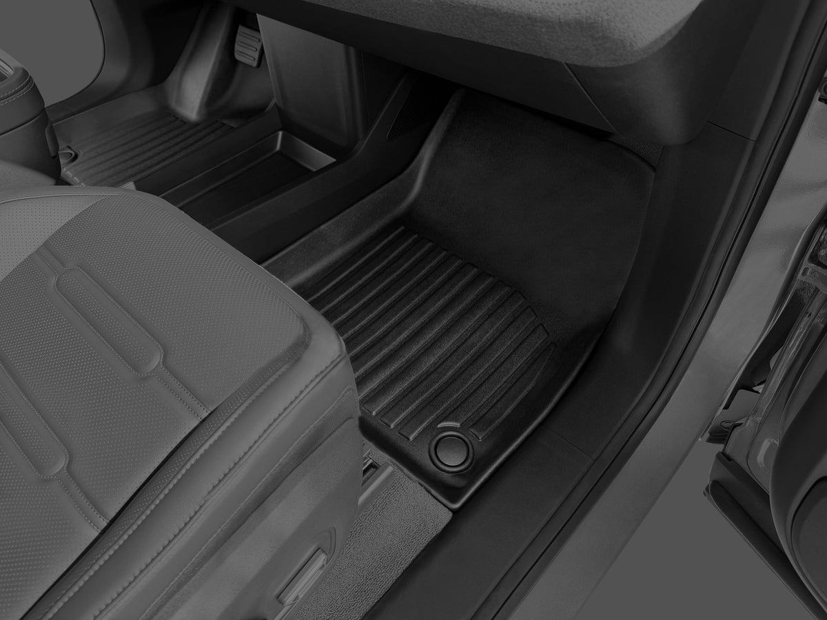 Black molded LinerX Floor Mats for Rivian R2 (2027) installed in the front footwell of a vehicle.