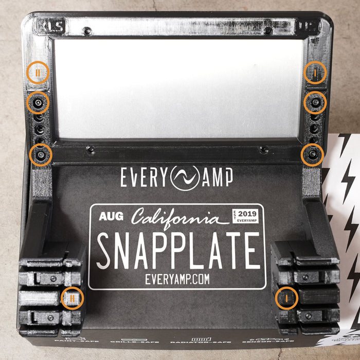 Top view of a SnapPlate device labeled EVERYAMP, showing six screw locations highlighted in orange circles. The product features a black base and is branded for August, California, 2019.