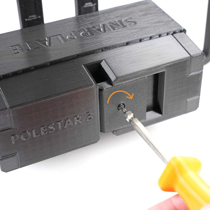 A hand uses a screwdriver to turn a screw in a black plastic device labeled POLESTAR 3 and SNAPPLATE, with an orange arrow indicating screw rotation.