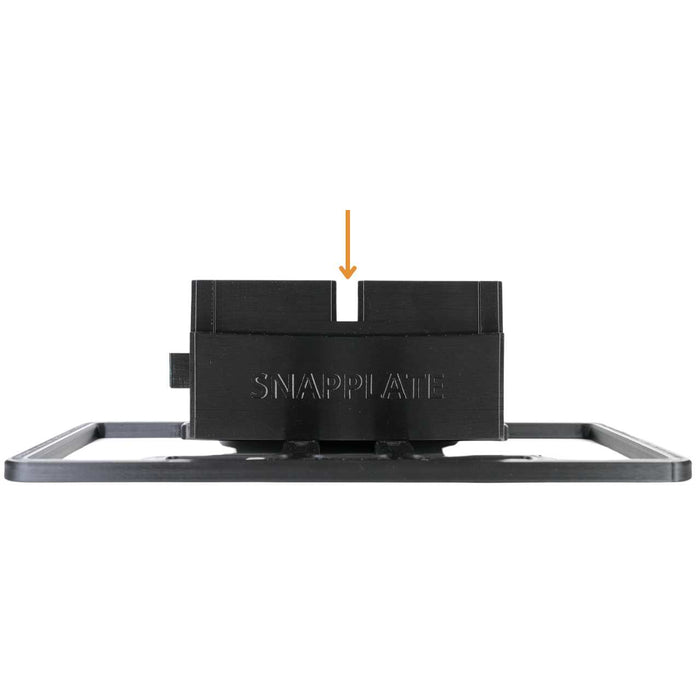 A black license plate holder labeled “SNAPPLATE” with an orange arrow pointing down toward a slot in the center of the holder.