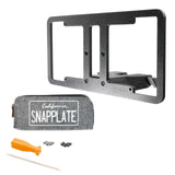 The EveryAmp SnapPlate Front License Plate Mount for Rivian R2 includes a black frame, orange screwdriver, screws, drill bit, and a gray California Snapplate pouch—making it a sleek 3D-printed detachable holder for your Rivian R2.