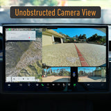 A car dashboard displays navigation on the left and three clear backup camera views showing a driveway and gate on the right. A label reading "Unobstructed Camera View" highlights the benefit of using a removable license plate holder like the EveryAmp Tesla Model S SnapPlate Front License Plate Holder, which keeps your cameras free from obstruction.