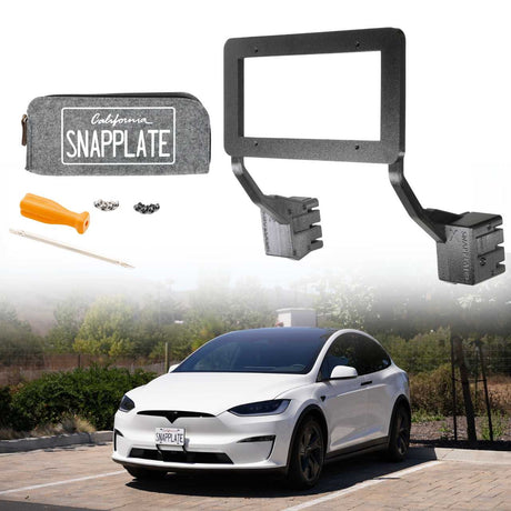 An EveryAmp Tesla Model X SnapPlate Front License Plate Holder with tools and hardware is shown above a white Tesla Model X parked outdoors, featuring the 3D-printed holder installed on the vehicle’s front.