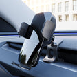 The Tesery Official Store Flexible Phone Holder for Model 3 Highland & Model Y Juniper is mounted on a car dashboard, with a modern building visible through the window in the background.