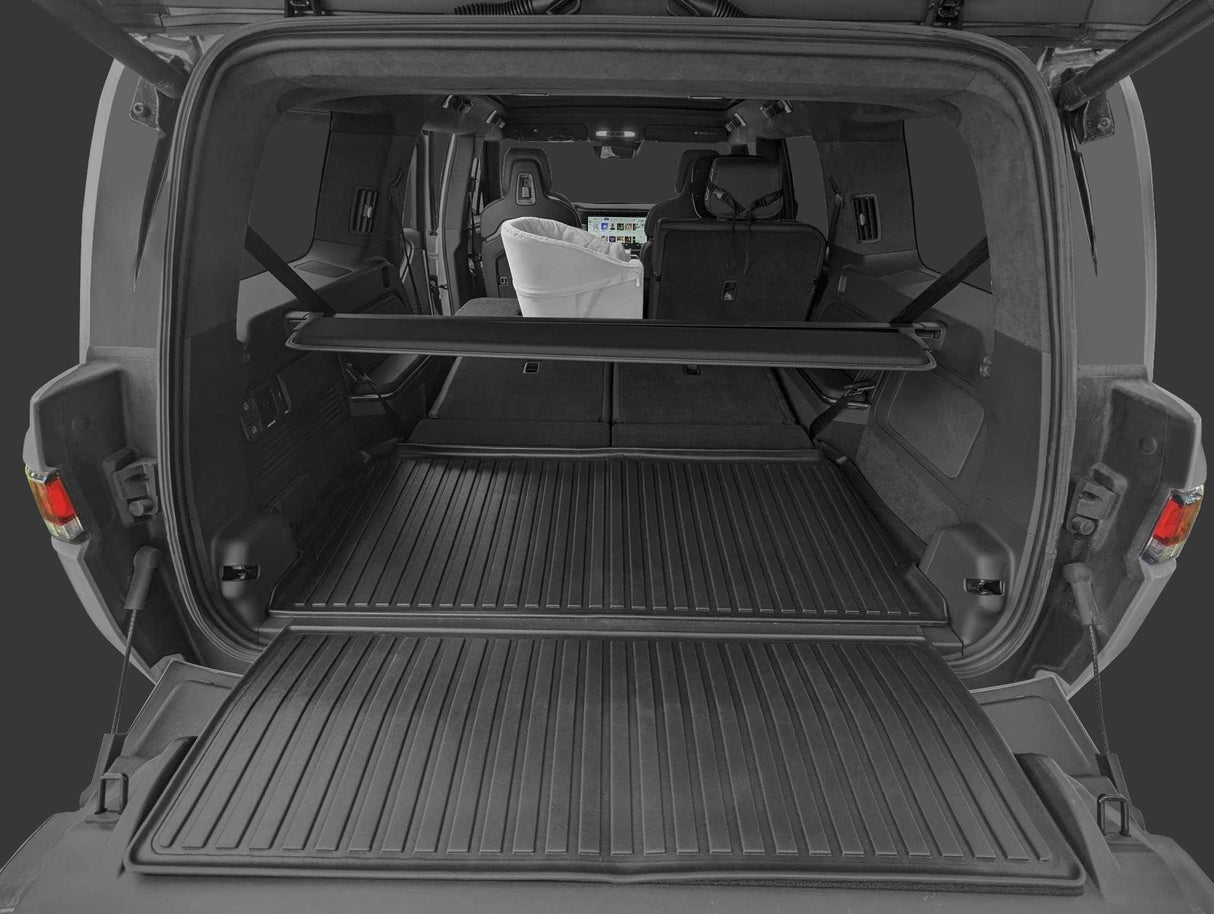 View of the LinerX Cargo Liner for 2022-2026 Rivian R1S in an SUV’s open trunk, with rear seats partially folded and a white car seat—showing all-weather protection and ideal fit for your Rivian R1S.