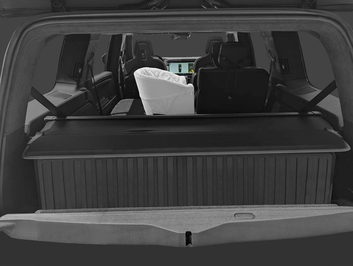 A rear view of the SUV shows a baby bassinet on the back seat, folded rear seats, and a LinerX Cargo Liner for 2022-2026 Rivian R1S—ideal all-weather protection for families upgrading their Rivian R1S with top accessories.