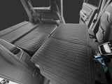 The rear seats of an SUV are folded flat, revealing LinerX Seat Back Cover Mats for 2022-2026 Rivian R1S—durable thermoplastic liners by LinerX that expand cargo space and add versatile protection.