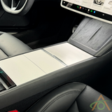 Close-up of a modern car interior showcasing the Abstract Ocean Center Console Vinyl Wrap for Refreshed Model 3 & Y, touchscreen display, and front seats with black and gray upholstery.