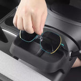 A hand places sunglasses into the Tesery Official Store Sunglasses & Phone Holder Organizer for Model Y Juniper, neatly showcasing its sleek in-car organization near the center console.