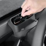 A hand places eyeglasses into the Tesery Official Store’s Sunglasses & Phone Holder Organizer for Model Y Juniper, mounted on the dashboard near the steering wheel for neat storage.