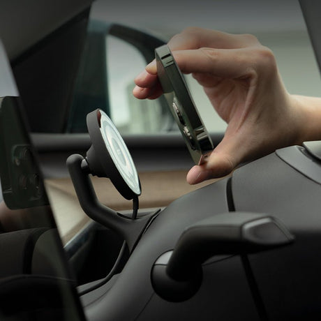 A person attaches a smartphone to the Tesery Official Store Magsafe Wireless Charging Phone Holder for Model Y/3 Highland on their Tesla dashboard.