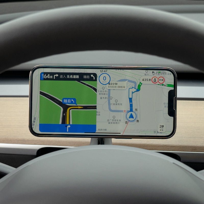 The Tesery Official Store Magsafe Wireless Charging Phone Holder for Model Y/3 Highland mounts on your dashboard, displaying GPS maps and directions through the steering wheel—ideal for Tesla drivers.